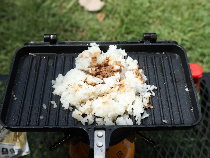①牛そぼろおにぎりを崩してホットサンドメーカーにのせ、弱火で温める
